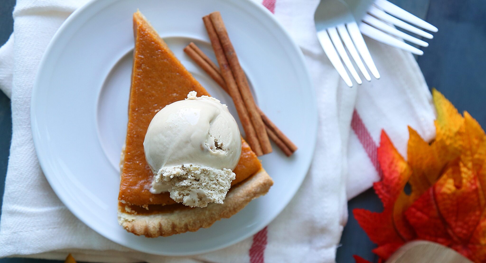 a slice of Pumpkin Pie topped with a scoop of Chapman's Ice Cream